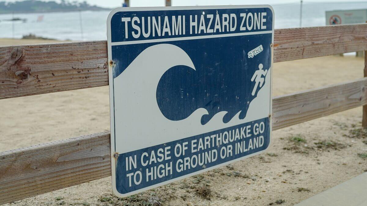 Sign on a fence that says "Tsunami hazard zone"
