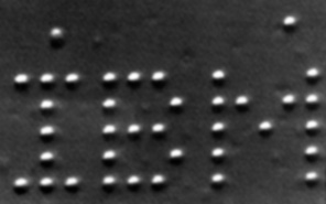 Black and white micrograph of the letter i b m spelled out by 35 xenon atoms