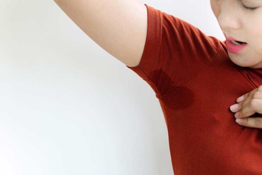 Woman looking at sweaty armpit