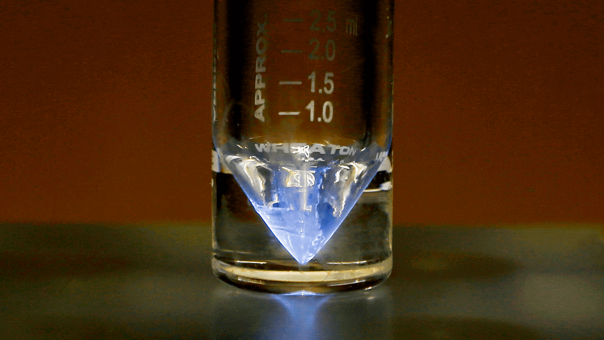 A vial of actinium-225 glowing blue