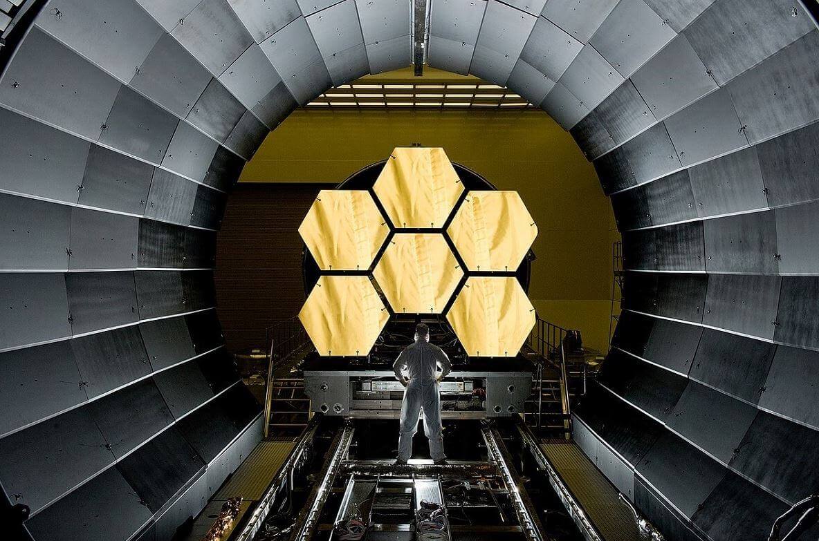Person stands in front of 6. 5 metre hexagonal golden mirror