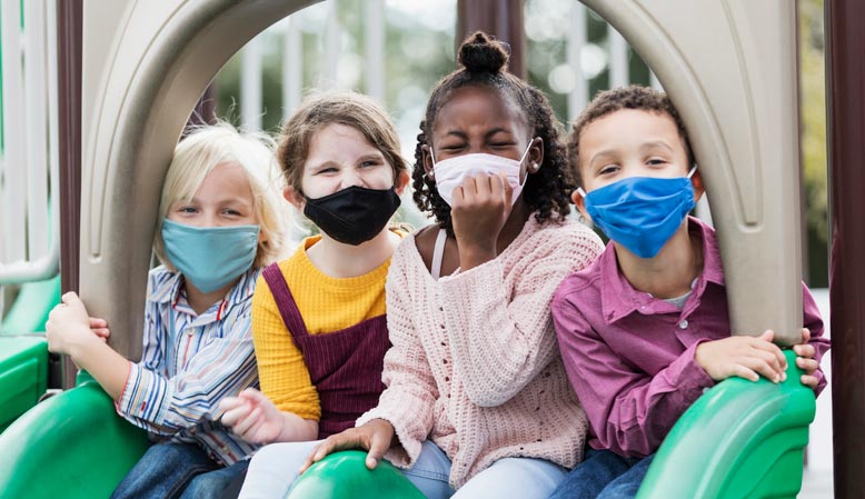 Children on a playground wearing face masks
