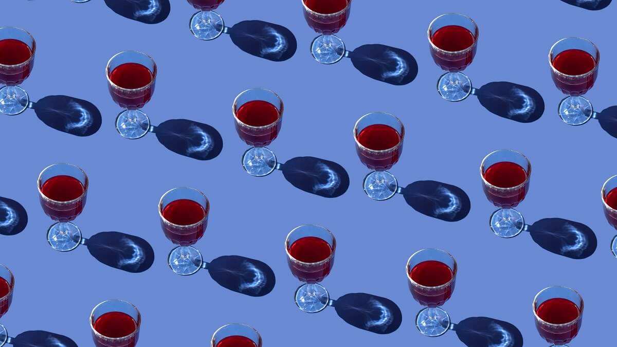 Glasses of red wine against a blue background.