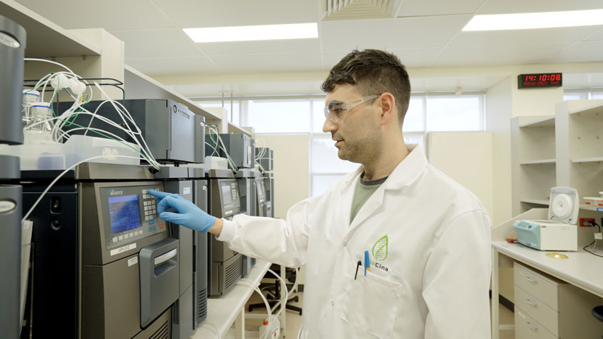 Man stands in a lab operating a machine