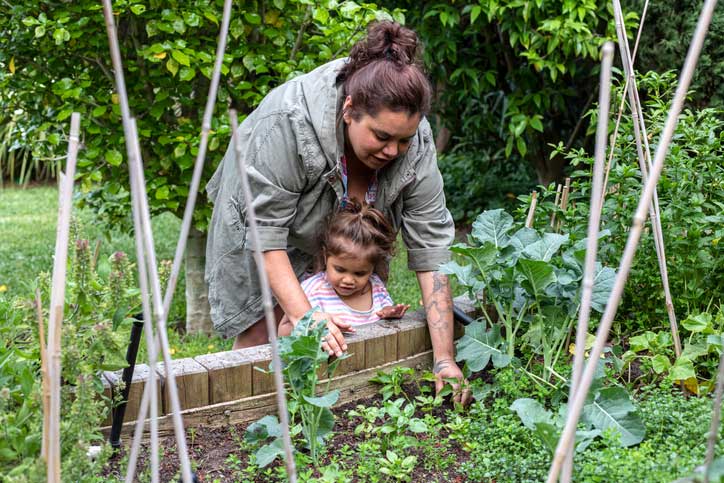 Food security in australia concept a woman in melbourne showing her small daughter how to care for a vegetable garden