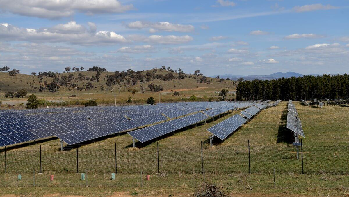 solar panels in an australian field with hills in the background