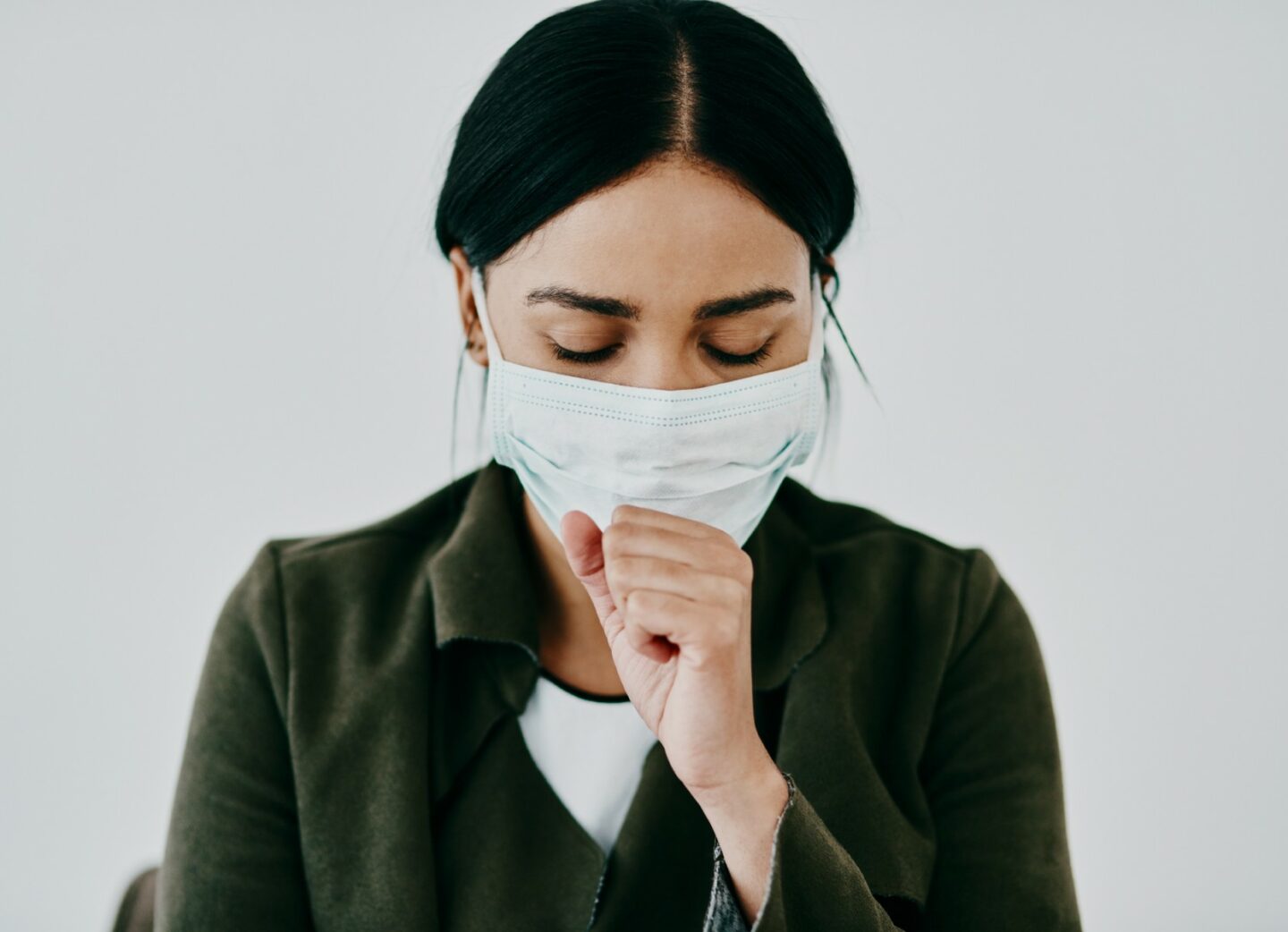 Person coughing wearing mask