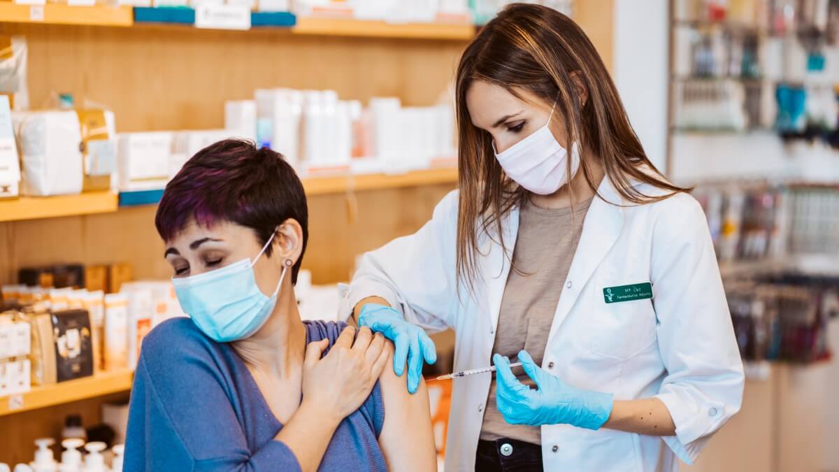 woman in pharmacy receiving influenza vaccination