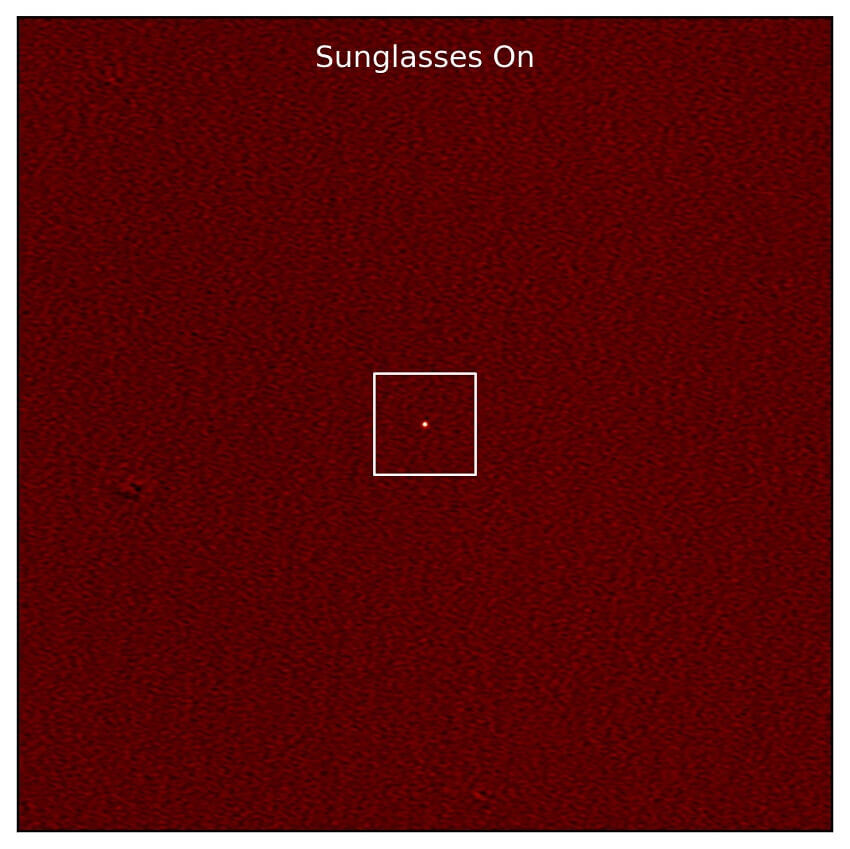 Picture labelled sunglasses on with tiny white dot on dark red field