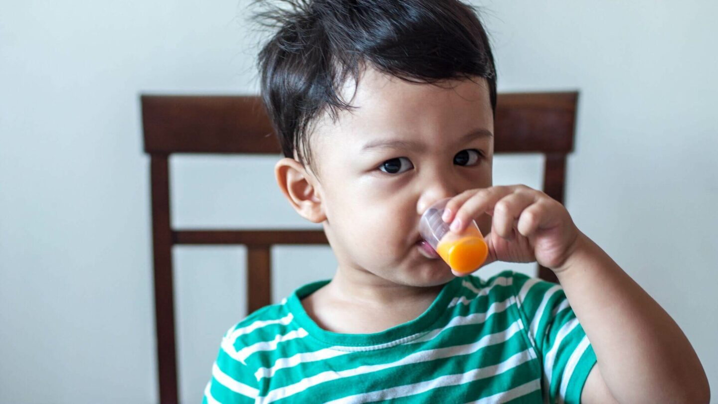 Child drinking an orange liquid