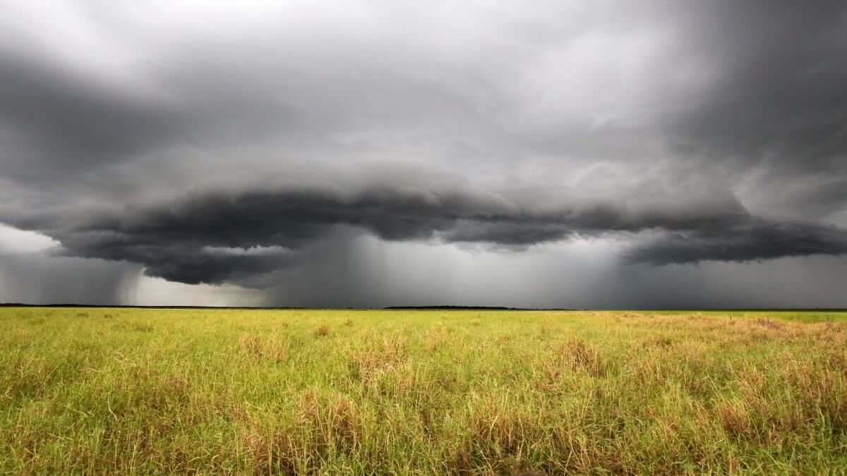 storm over dry fields, representing flood and drought