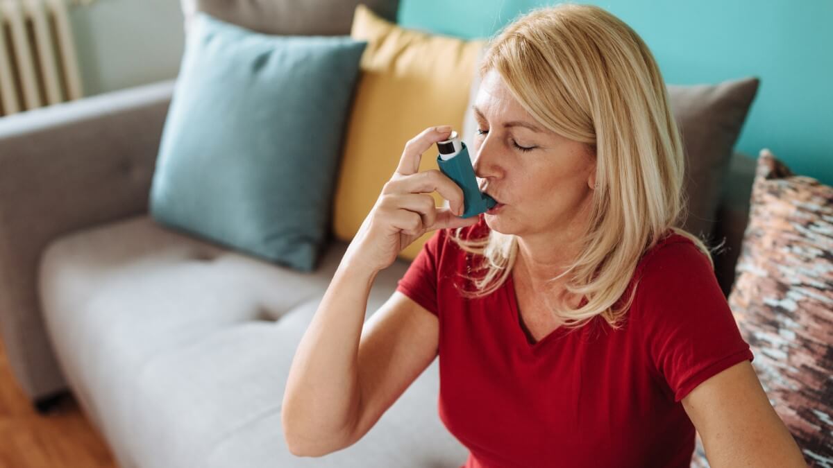 woman inhaling from asthma puffer