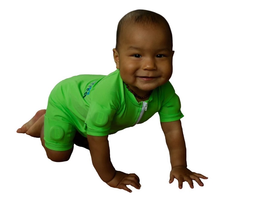 Baby crawling wearing smart jumpsuit, it is a bright green jumpsuit with round sensors visible on arms and legs