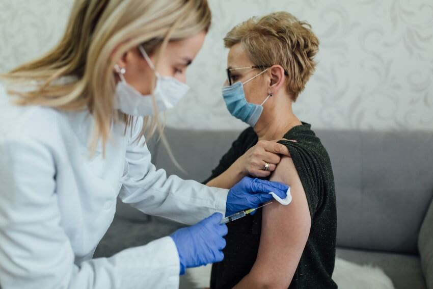 Flu season concept a masked middle-aged woman receiving an influenza vaccination