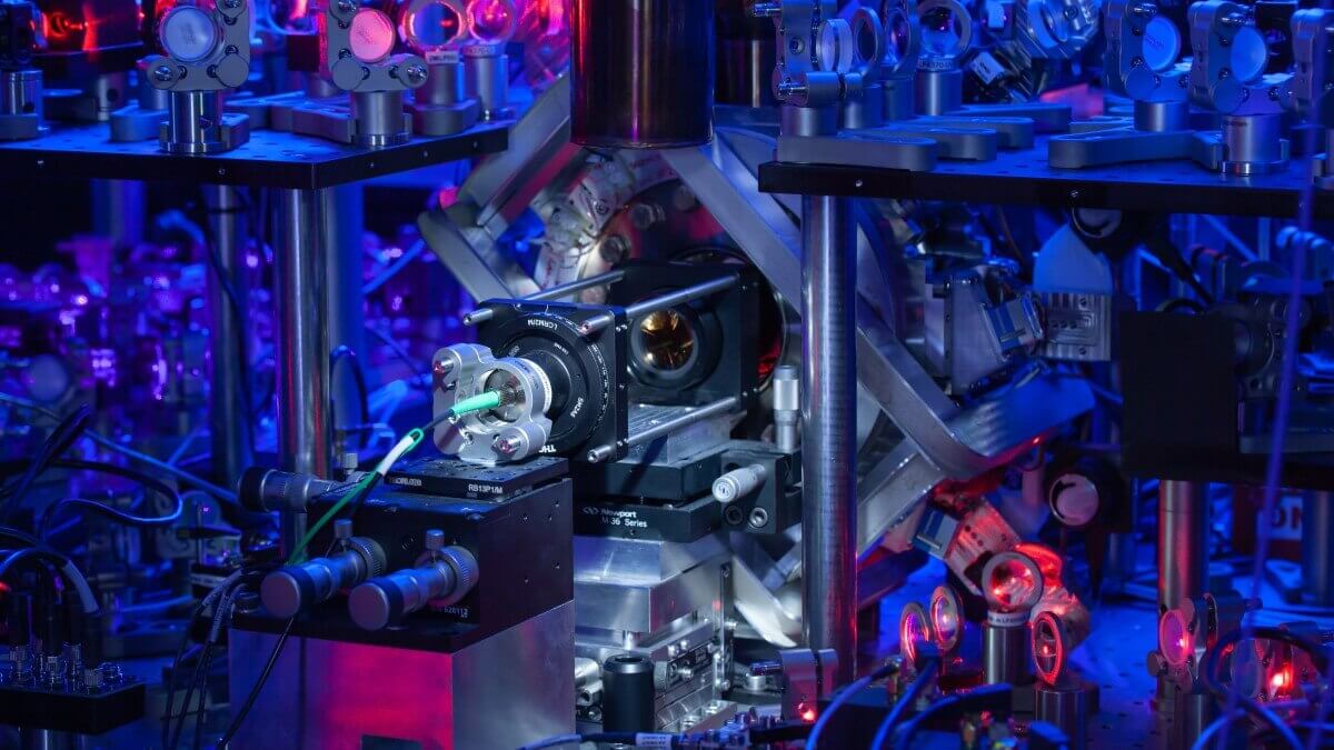 silver machinery in a room lit by blue and red light, half of a quantum encryption experiment