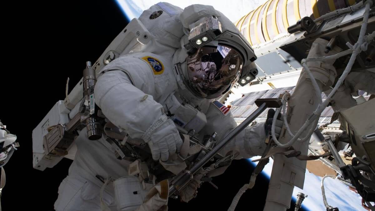 astronaut during spacewalk on international space station - a long time in zero gravity causes loss of bone density