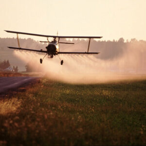 A plane sprays plant crops with pesticide