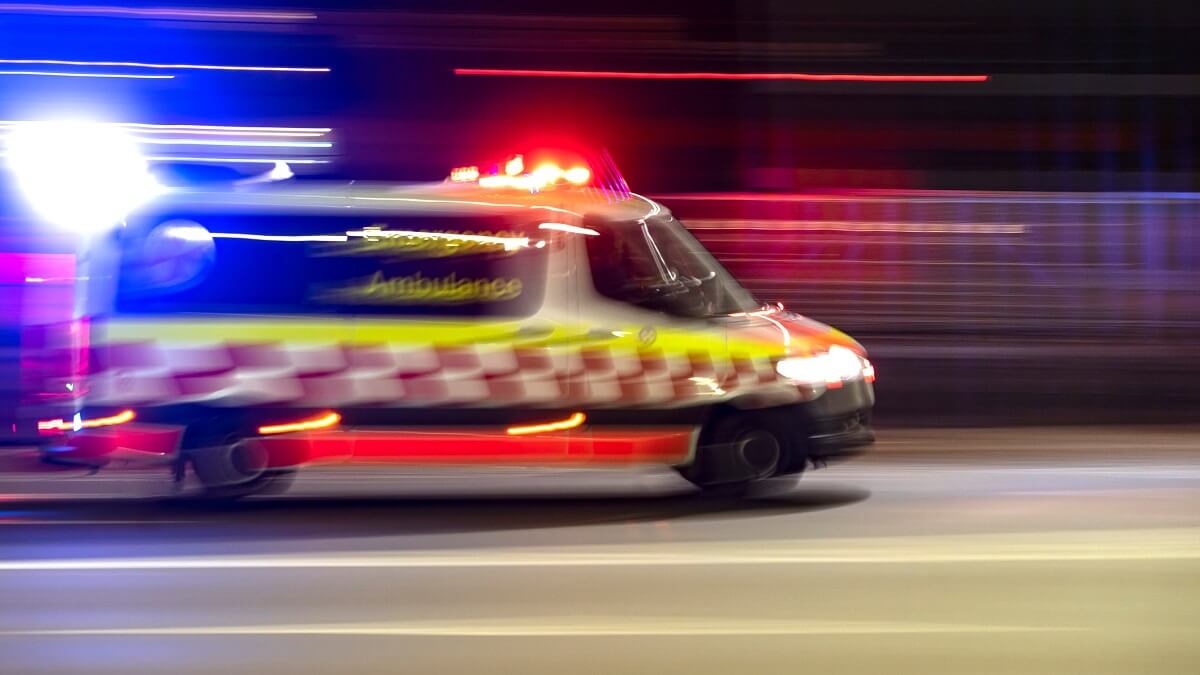 A motion blurred image of an Autralian ambulance at night