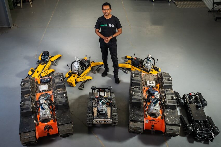 Roboticist navinda kottege stands around several robots