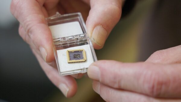 hands holding semiconductor chip in small plastic case