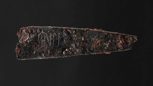 ancient blade with runes on it against black background