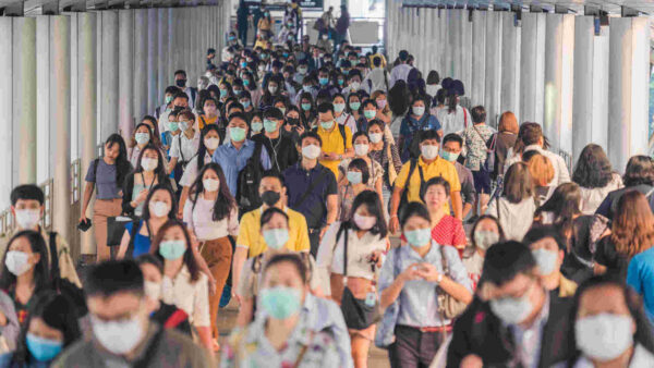 Crowds of people wearing face protection while going to their workplace in Bangkok at morning rush hour