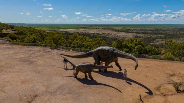 two sauropod dinosaur sculptures in outback australia with three people