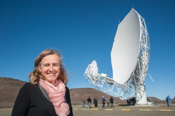 Woman in front of telesope searching for galaxies
